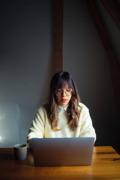 istock Focused Woman Working on a Laptop in a Cozy Home Setting 2202165958