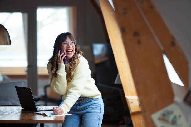 Happy Woman Working Remotely and Speaking on Phone in Cozy Environment