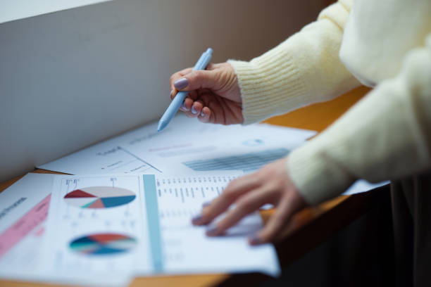 Professional Hands Reviewing Charts and Graphs in an Office Setting