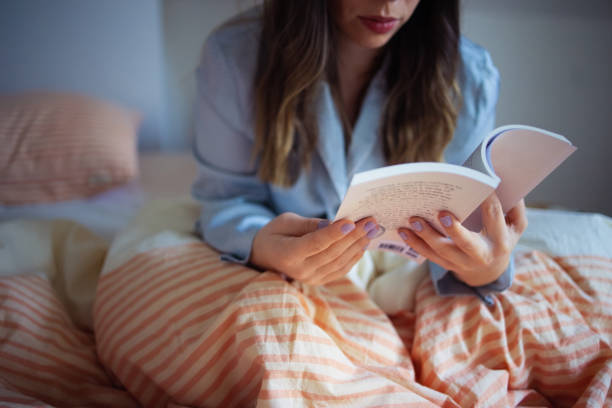 Woman Relaxing in Bed Reading a Book on a Cozy Evening