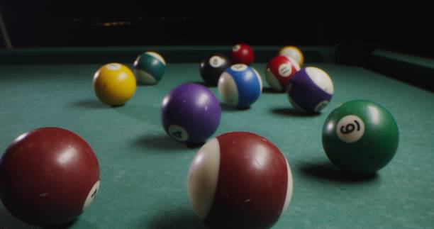 istock Multi-colored billiard balls in a chaotic manner lie on the billiard table 2202168457