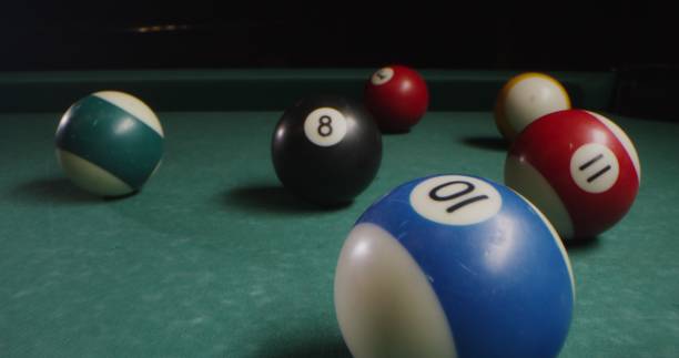 istock Multi-colored billiard balls in a chaotic manner lie on the billiard table 2202168460