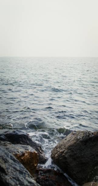 istock Sea waves hit large rocks on the coast, splashing in different directions 2202171011