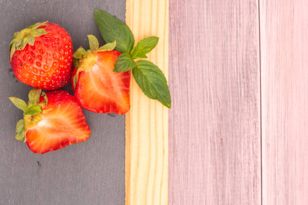 Fresh strawberries in bowl on slate. Top view with copy space