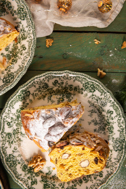 istock Festive Bolo Rainha slice on green plate, with powdered sugar, almonds & walnuts, on a green table with Christmas decor. A traditional Portuguese Christmas, New Year's & Epiphany dessert. 2202171444
