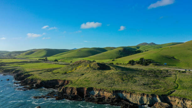 istock Scenic coastal landscape featuring rolling green hills alongside a serene ocean 2202172798