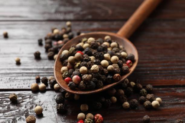 istock Aromatic spice. Different peppers in spoon on black table, closeup 2202175528