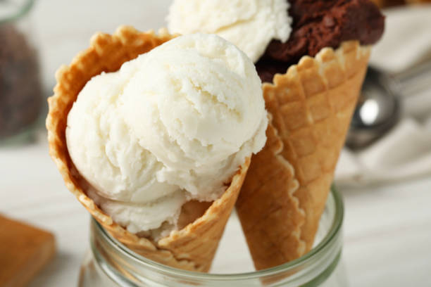 istock Ice cream scoops in wafer cones on table, closeup 2202175899