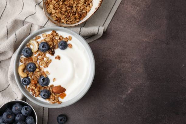 istock Bowl with yogurt, blueberries and granola on grey table, top view. Space for text 2202175956