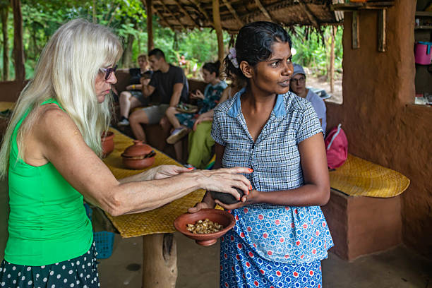 Sri Lankan woman serving food to tourists during village tour stock photo