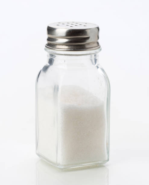 istock Glass salt shaker filled with white salt on a plain background 2202177744