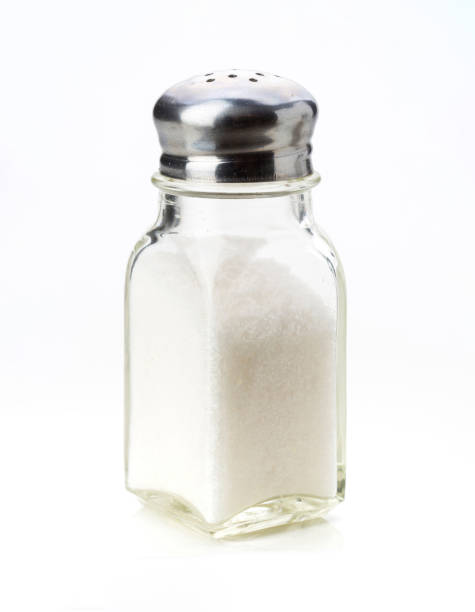 istock Glass salt shaker with silver lid on plain background for culinary use 2202177749