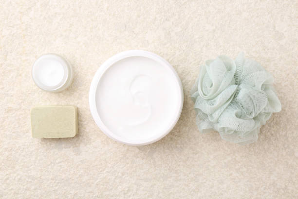 istock Composition with body care cream in open jars and soap bar on light textured table, flat lay 2202178861