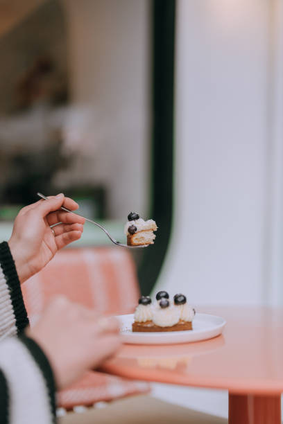 istock A Woman Eating Sable Breton, mini tart 2202178996