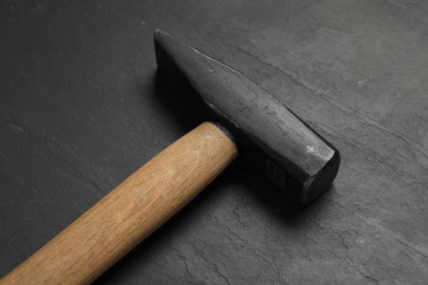 istock New hammer on black textured table, closeup. Professional construction tool 2202179994