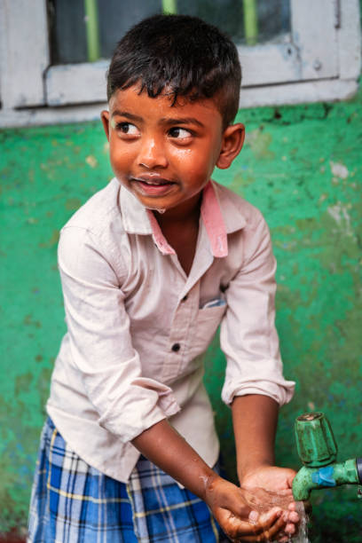 Sri Lankan young boy drinking a fresh water, Haputale, Ceylon.