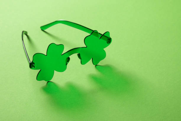 St Patricks day and March 17 traditional eyeglasses as clover leaf on green background. Close up. Festive lucky outfit or accessories. Copy space.