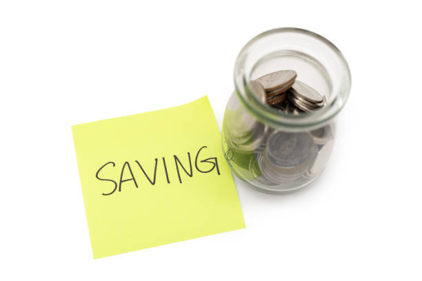 istock SAVING text with sticky note and Coins in glass money jar isolated on white background, financial concept. Saving money concept. 2202187320
