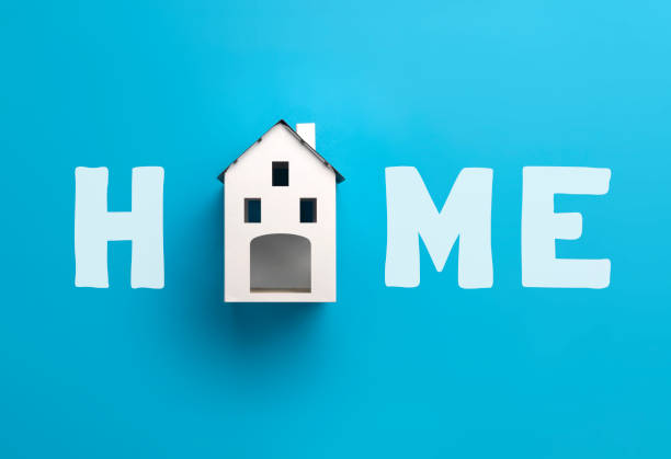 Overhead view of a model house creating the text word home on a yellow background