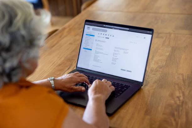 Senior woman at home checking her e-mail on her laptop