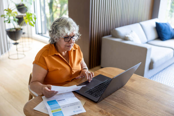 istock Senior woman paying bills online from home 2202195064