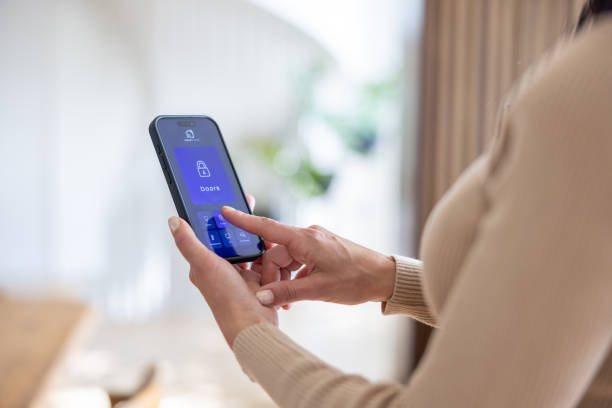 istock Woman locking the door of her house using a mobile app 2202195614