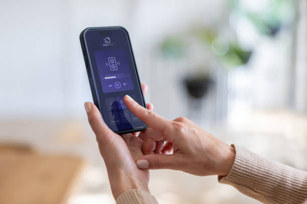 istock Woman controlling the music in her smart home using her cell phone 2202196815