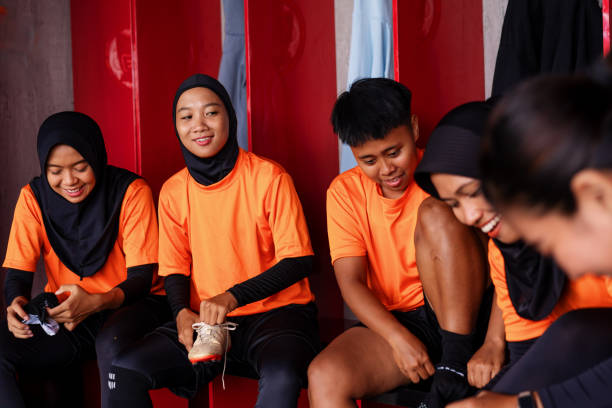 istock Diverse Southeast Asian Female Soccer Team Preparing in Locker Room Before a Match 2202197739
