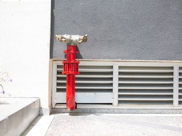 istock The red fire extinguishing system connection pipe is installed on the gray wall outside the building. 2202198303