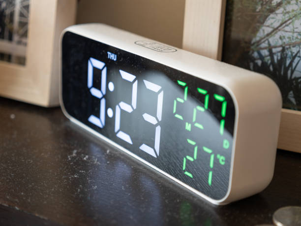 istock Digital alarm clock displaying time and temperature cozy bedroom setting 2202198629