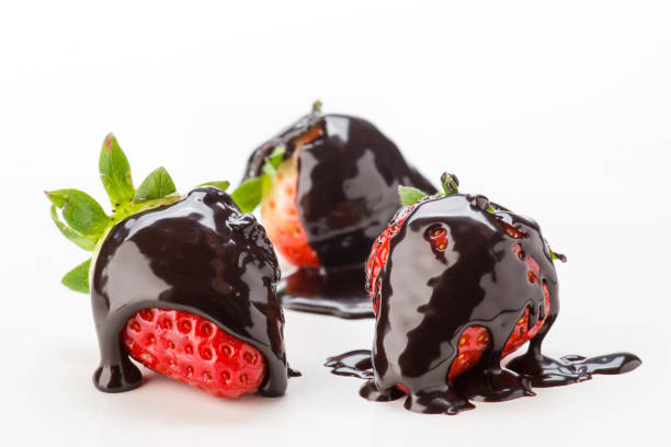 istock Fresh strawberries coated in rich chocolate sauce on a clean white background 2202200489