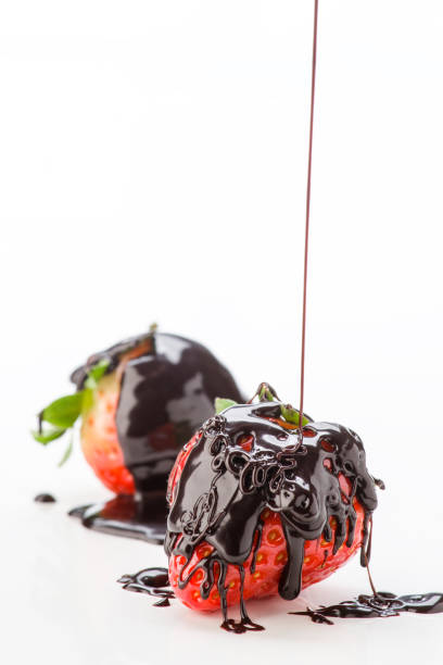 close up of three chocolate covered strawberries on a white background