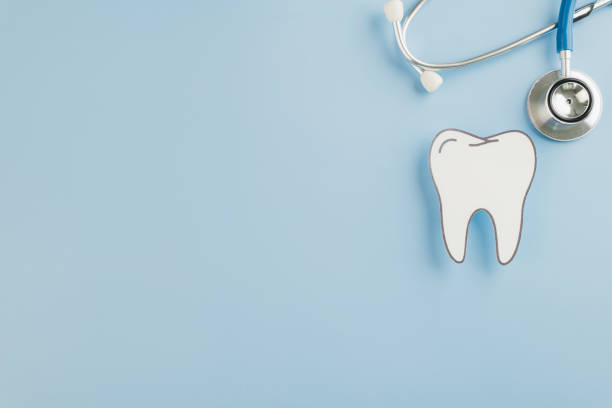 istock A stethoscope and paper cut tooth represent Dentist Day on a blue background 2202200896