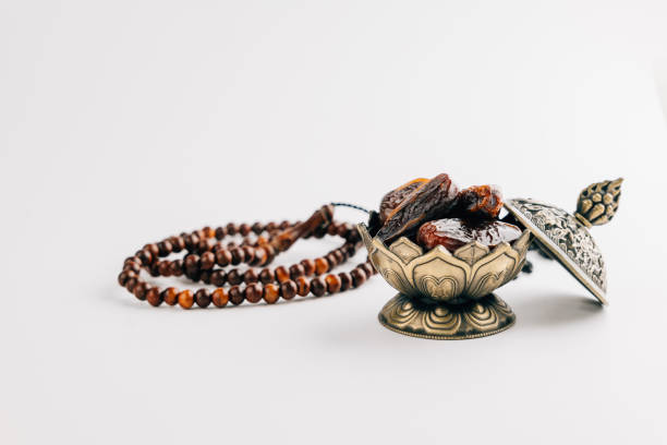 istock Holy Ramadan celebration with dates in ornate dish and prayer beads on a simple white background 2202201472
