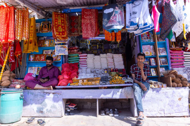 A mid-adult woman buys saris in a local handloom sari shop in Karaikudi, Tamil Nadu. The shop's ambiance exudes the charm of traditional textile craftsmanship, offering a glimpse into the vibrant culture and heritage of the region.