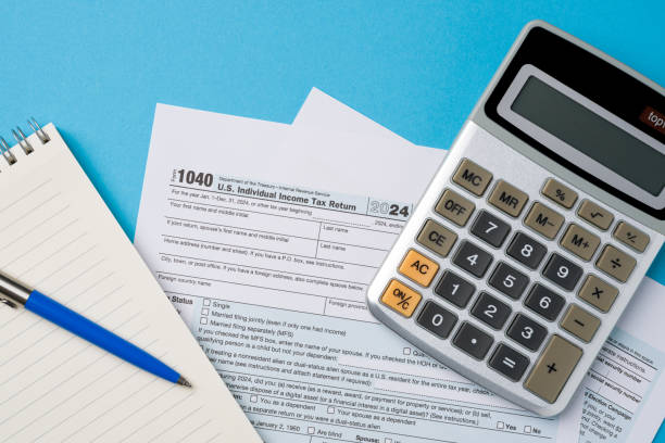 istock Top view of tax forms, calculator and pen on blue table 2202208265