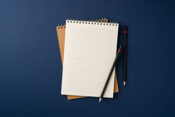 istock Top view of notebook and pencil on blue background 2202208295