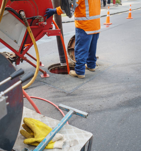 istock Worker unblocking sewers through a manhole on street. Auckland. 2202210310