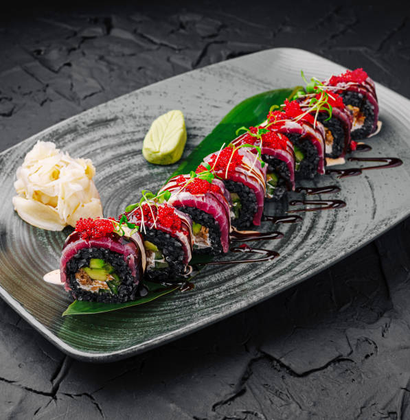 istock Colorful sushi rolls served on a decorative plate with garnishes in a modern restaurant setting 2202211948
