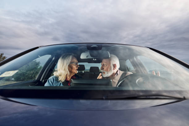 istock Frustrated senior couple arguing during trip by a car. 2202211975