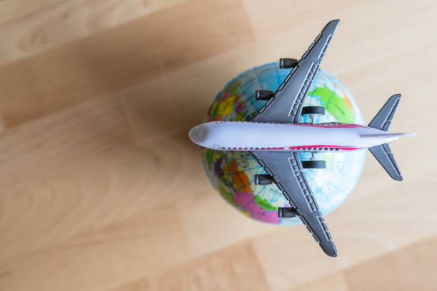 istock Miniature airplane soaring above a small globe on a wooden table captures the essence of planning and booking flights for adventures around the world, igniting wanderlust and exploration 2202212213