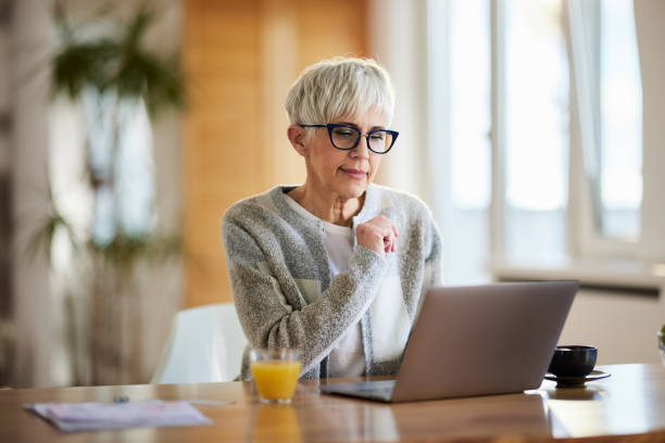 istock Senior woman reading an e-mail on laptop at home. 2202212961