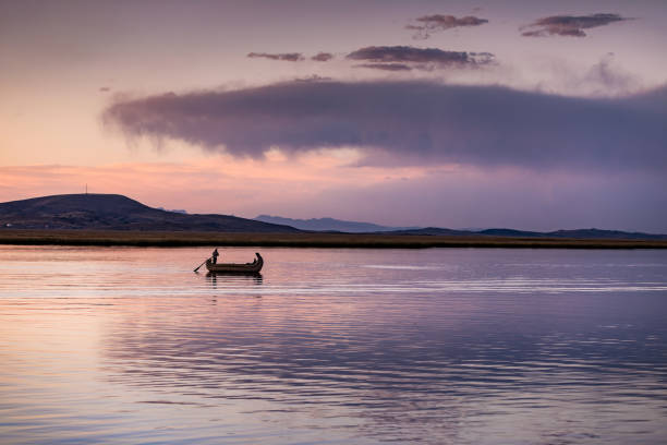 Sunset over Lake Titicaca in Peru with a fisherman returning back home
