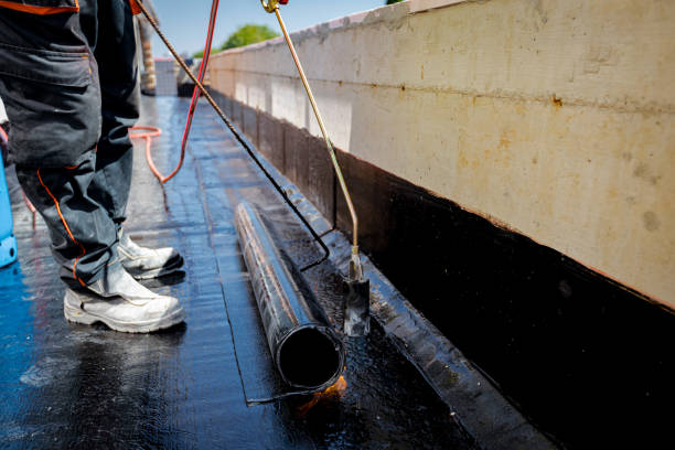 istock Worker using a gas burner, propane blowtorch to melt and arrange resin as unroll foil with bitumen 2202214849