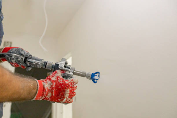 istock Worker is applying skim coating material to the wall before painting 2202214898