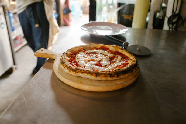 A freshly made marinara pizza in commercial kitchen with natural light ready to eat.