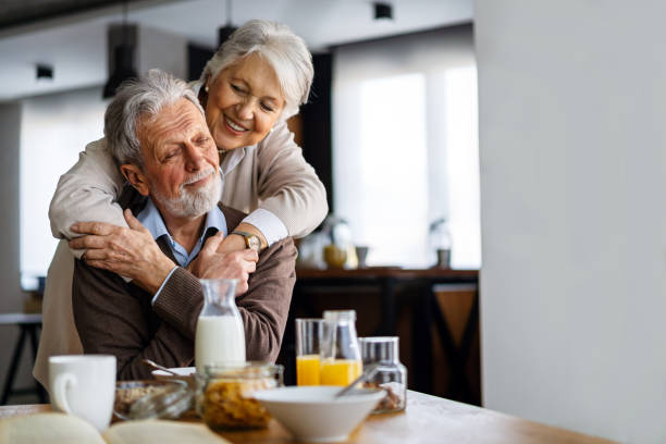 istock Beautiful senior couple having fun, smiling together while enjoying breakfast together 2202223139