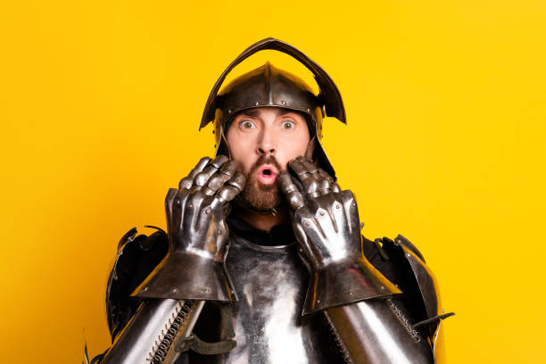istock Surprised knight in medieval armor posing on vibrant yellow background 2202224249