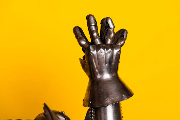 istock Medieval armored gauntlet displayed against a vibrant yellow backdrop 2202224322