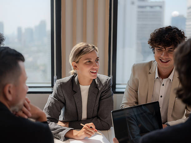 istock Business Team Discussing Strategy in Modern Office with City Sky 2202225925